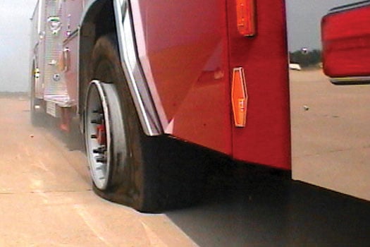 Pierce Manufacturing firetruck parked outside on the road showing the Roll Stability Control system. 