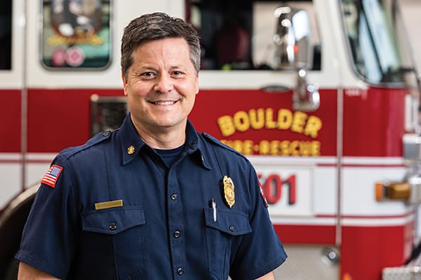 Boulder Fire-Rescue Fire Chief posed in front of a Pierce fire truck