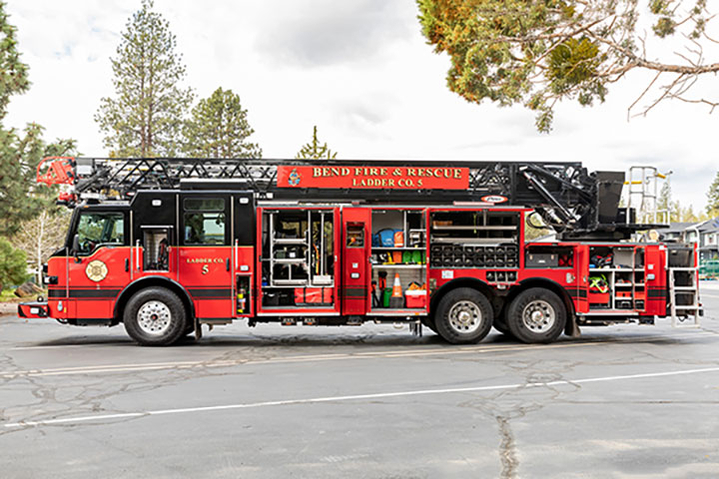 Velocity Ascendant 107 aerial ladder drivers side with compartments open showing equipment.