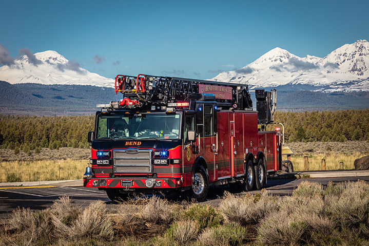Velocity Ascendant 107 aerial ladder parked on a road in front of mountains on a sunny day.