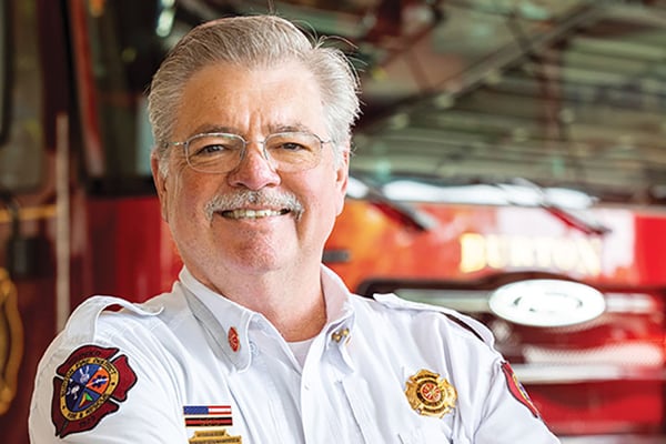 Burton Fire District Fire Chief posed in front of a Pierce fire truck.