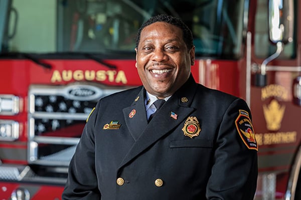 Augusta Fire Department Fire Chief posed in front of a Pierce fire truck.