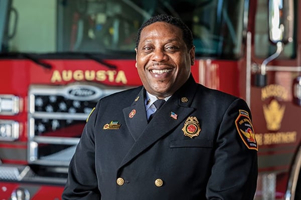 Augusta Fire Department Fire Chief posed in front of a Pierce fire truck.