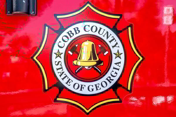 A fire truck door with a graphic of the maltese cross for Cobb County Fire and Emergency Services in Georgia.