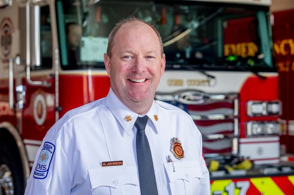 The chief of Cobb County Fire and Emergency Services in Georgia in front of a fire truck at a fire station.