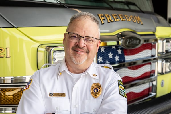 The fire chief of Freedom Volunteer Fire Department posed in front of a fire truck.