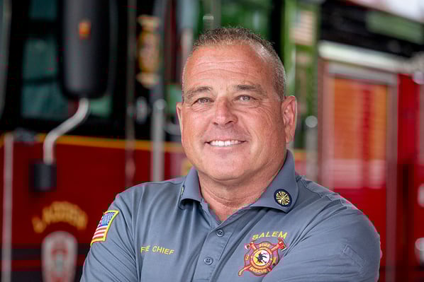 The fire chief of Salem Fire Department in Massachusetts standing in front of a fire truck.