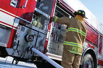 A Firefighter controlling a Pierce PUC™ Pump panel on the driver’s side of a Pierce Fire Truck.