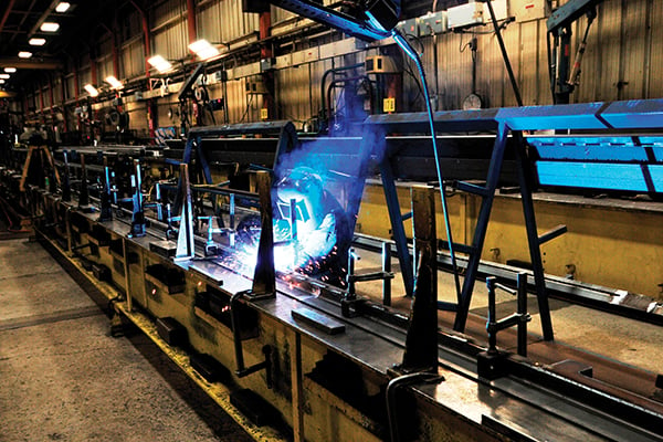 A person welding parts of a Pierce Aerial Fire Truck at a Pierce facility. 