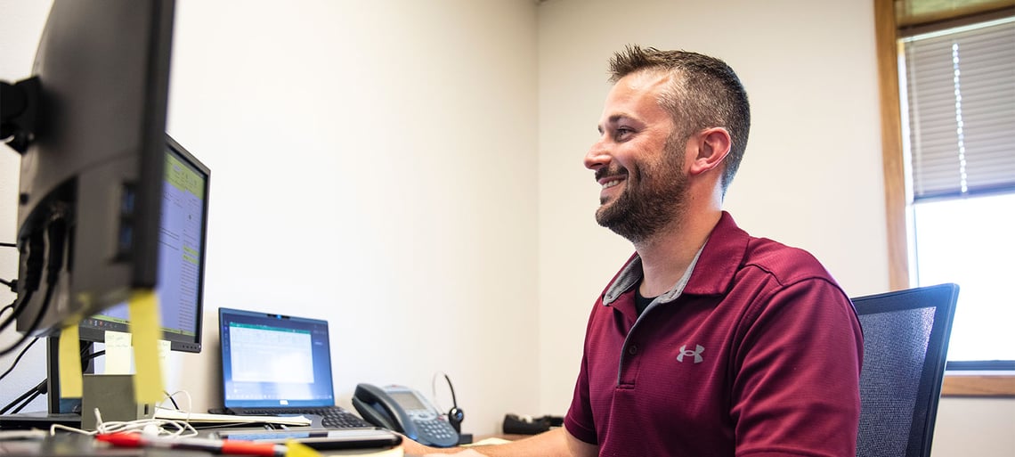 An aftermarket team member working at a computer desk finding fire truck parts for fire departments.