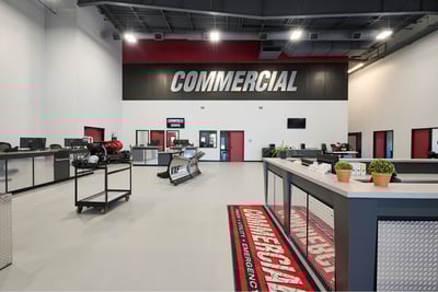 An interior photo of Commercial Emergency Equipment shows a long desk area and several workstations with ‘Commercial’ painted on the wall in the background. 