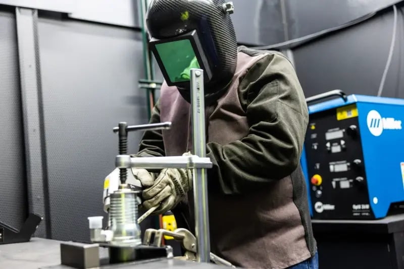 A technician uses a handheld laser welding tool at a Pierce Manufacturing fabrication facility.