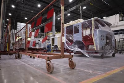 Painted fire truck components and cabs in a modern Pierce Manufacturing paint facility.