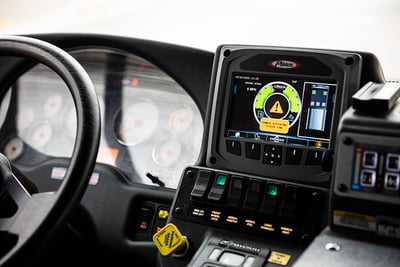 An interior image of a fire truck dashboard shows a touchscreen with an alert message over a circular graph.