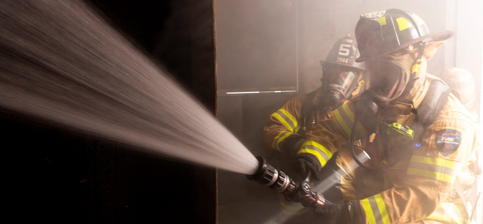 firefighters-in-turnout-gear-spraying-hose