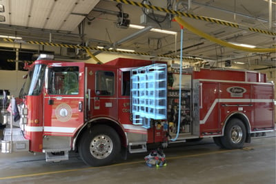 A red electric fire truck has a graphic overlay showing the batteries used to power the system. 