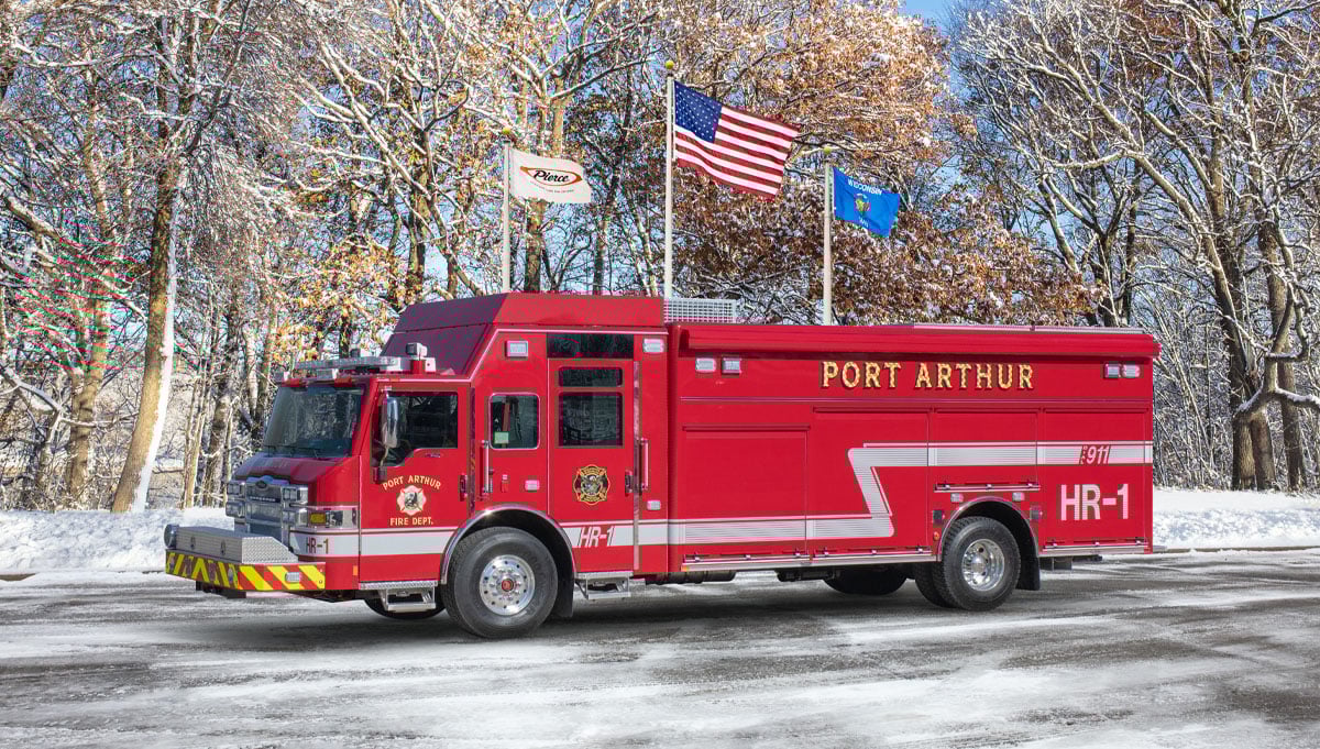 The red Port Arthur Fire Department combination rescue is parked showing the driver side with a winter background. 