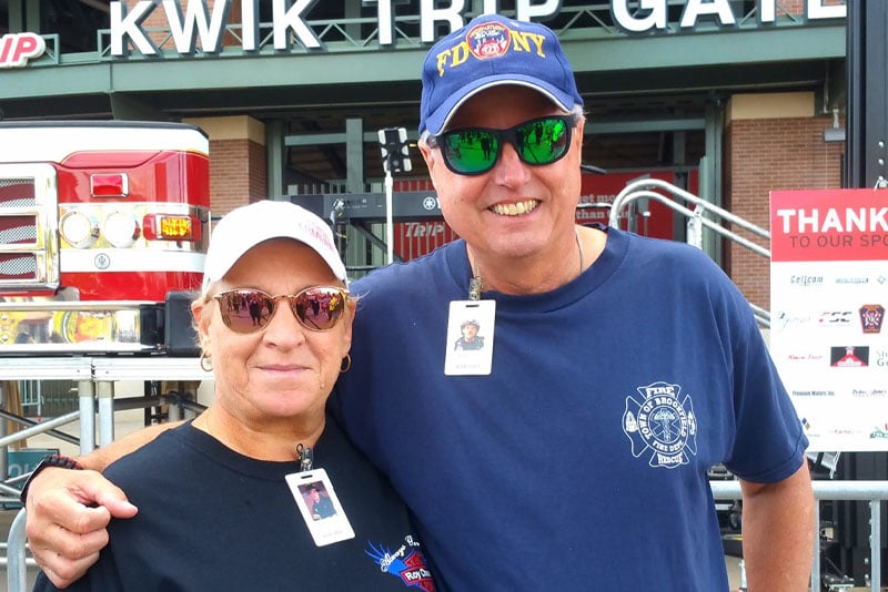 A woman and man stand in front of the Kwik Trip Gate at Lambeau Field after the 9/11 Memorial Stair Climb.