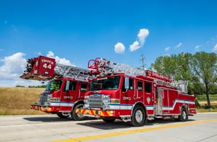 Two Overland Park Pierce aerial fire trucks, a quint and a platform truck, parked side by side.