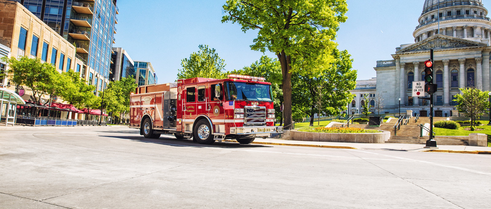 Madison’s electric fire truck is parked on the road in front the Wisconsin State Capital Building. 