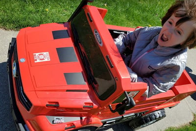 Addi Carroll driving a mini battery powered Pierce-branded fire truck