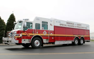 Side and front view of a Pierce Manufacturing Combination Rescue Truck. Showing compartments and storage area along side the apparatus.