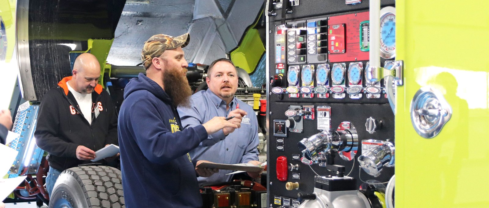 Pierce representatives and customers talk and final inspect their fire truck on the Pierce Blue Floor.