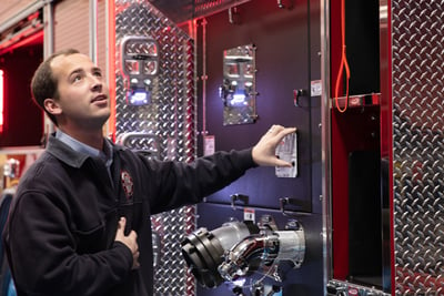 Pierce provides to their dealers educated and experienced sales and service members, pictured is a young man showing technical support on a fire apparatus  