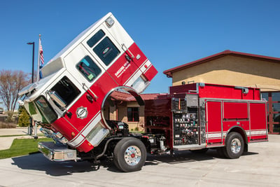 A Pierce fire truck cab is raised to show the easy access to the fire truck engine.