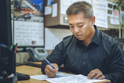 A fire truck engineer reviews a rendering and fire truck crashworthiness testing in an office setting.