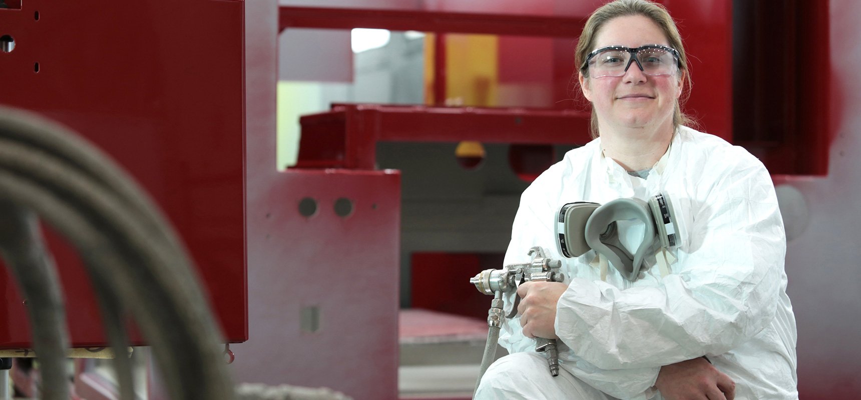 Woman Pierce employee painting a fire truck red 