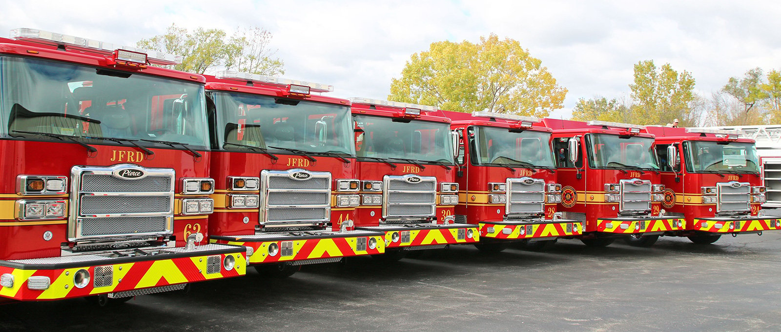 Six Pierce fire trucks lined up showing the JFRD standardized fleet.
