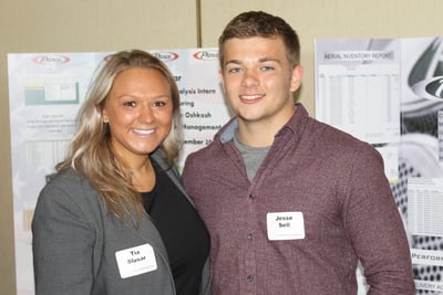 Two Pierce interns standing in front of their projects from the Pierce Intern Expo 