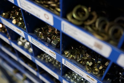 A shelf with cubbies filled with Pierce apparatus parts, washers, bolts, nuts, etc.