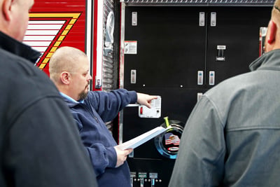 Pierce employee shows the quality of Pierce’s fire truck by inspecting the fire truck with the customer.