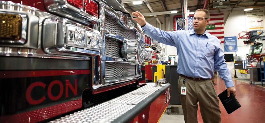A Pierce employee showcases a fire truck for the customer during the ordering process.