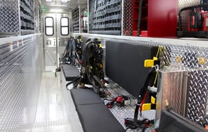 Interior view of a Pierce Manufacturing Walk-In Rescue Truck. Seating is shown as a bench along the side of the interior for first responders to sit