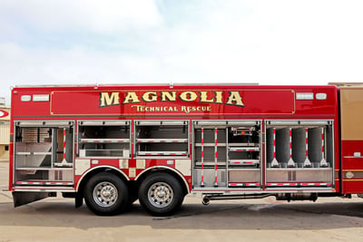 A red non-walk-in fire truck has all body compartments open showing the available storage on the unit. 