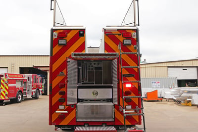 A red and orange stripped rear end of a rescue apparatus shows the storage compartments and roof storage. 