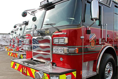 Up close view of four standardized Pierce fire apparatus lined up in a row.