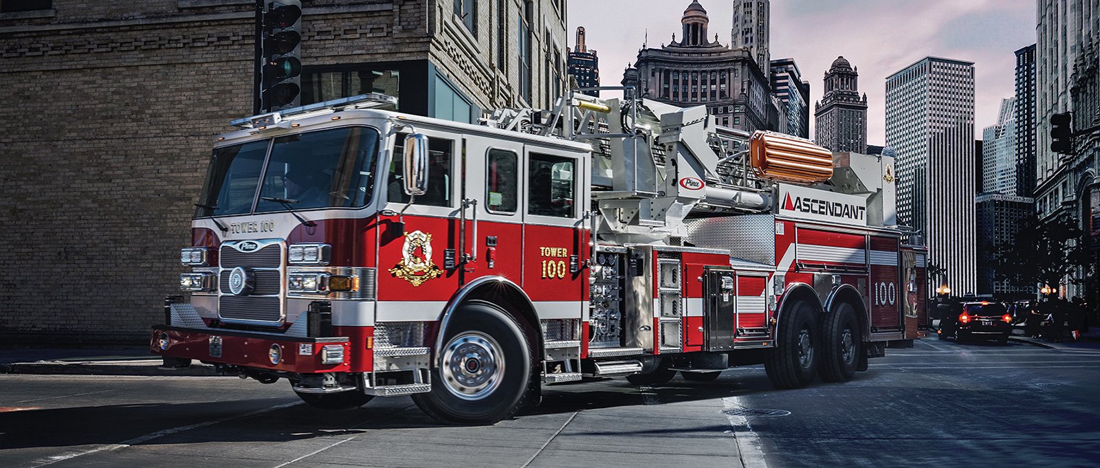 A Pierce ascendant aerial tower apparatus shows maneuverability driving through a narrow urban street.