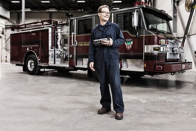 Fire apparatus customizations start with experienced team members who understand every aspect of fire apparatus. Pierce employee shown standing in front of fire apparatus with controls in hand 