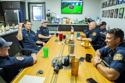 Fire department personnel sit around a rectangular table as they undergo training. 