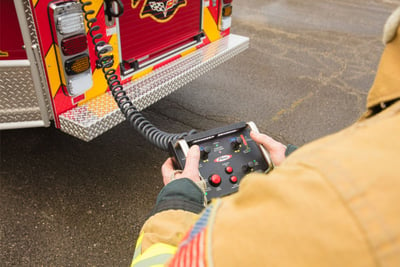An aerial operator demonstrates how a hand-held control can be used to strategically move an aerial ladder at an emergency scene. 