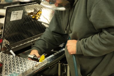 A fire truck compartment with an open panel door is sanded to a smooth finish.