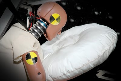 A fire truck crash test dummy hits an airbag in a simulated cab crash scenario to test cab safety systems.