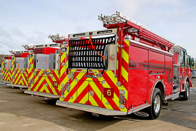 Four Pierce fire apparatus lined up displaying the rear view of the apparatus all part of a standardized fleet.