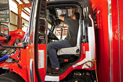 A fire truck is undergoing interior cab assembly in a fire truck manufacturing facility.