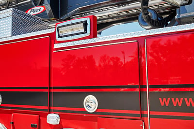 A red hinged fire truck door with a black stripes is shown in the closed and locked position. 