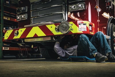 A mechanic performs a routine inspection of fire truck undercarriage, which can help to reduce surface rust and corrosion. 